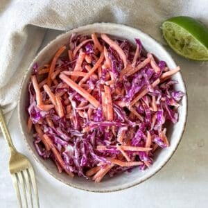 close up overhead view of purple cabbage coleslaw in a bowl.