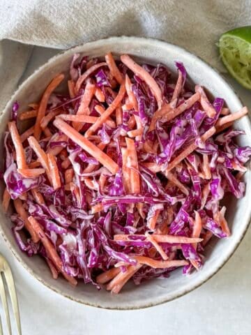 close up overhead view of purple cabbage coleslaw in a bowl.