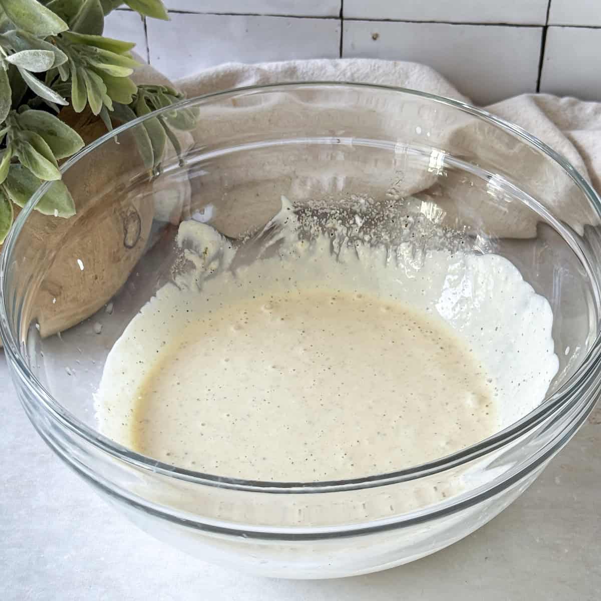 creamy dressing ingredients for red cabbage slaw in a glass bowl.