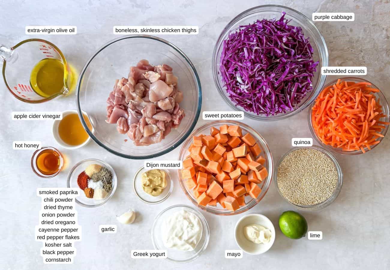Ingredients to make a hot honey chicken bowl in separate containers on a table with a grayish white background. The ingredients are lableled.