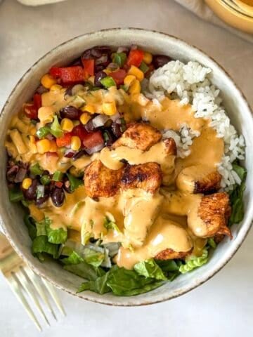 southwest chicken bowl with southwest dressing on top.