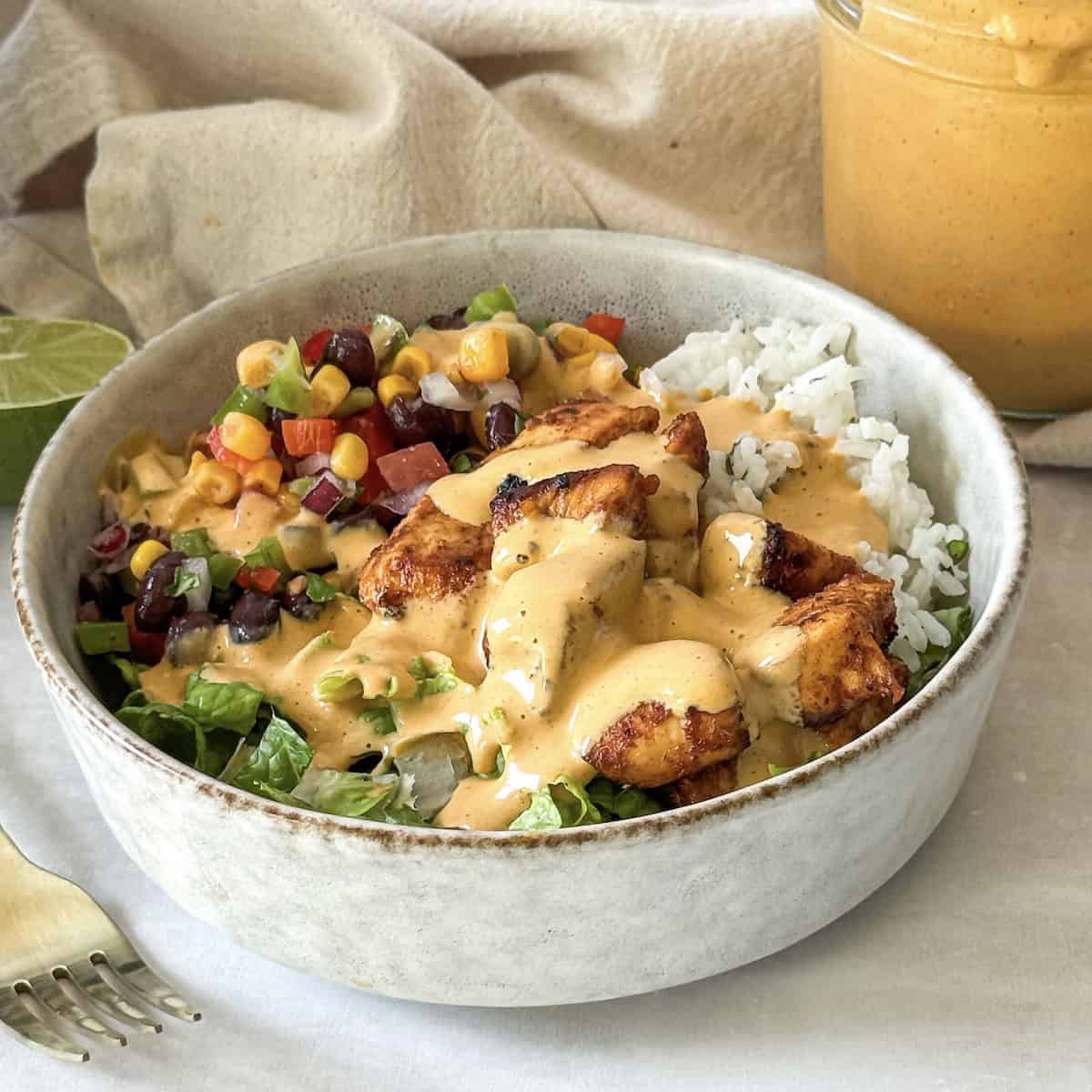 southwest chicken bowl with southwest dressing on top.
