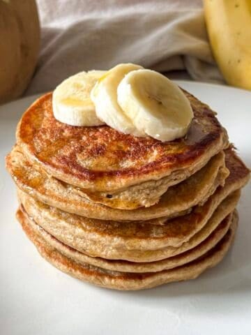 stack of banana oatmeal pancakes on a table.