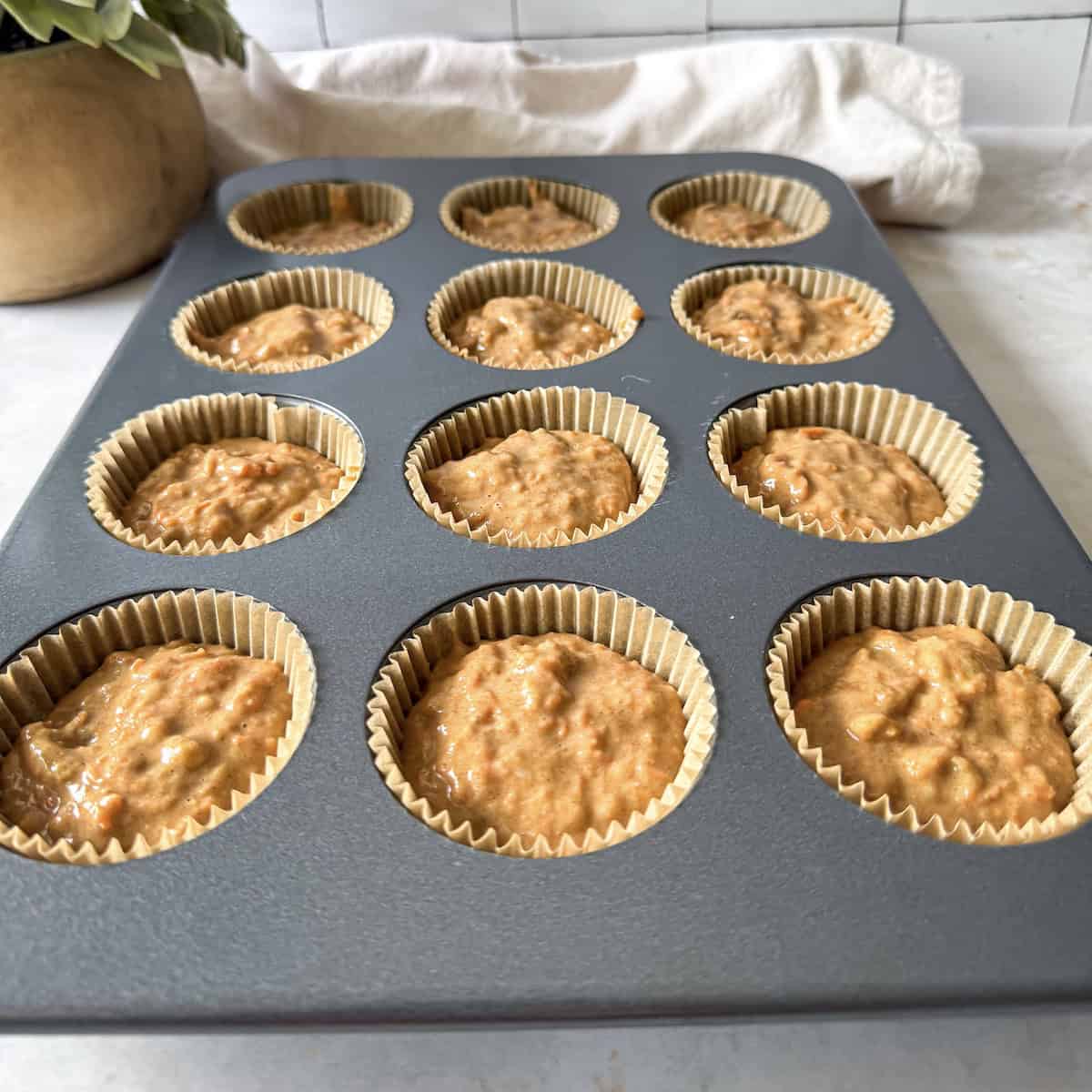 carrot and banana muffin batter in muffin pan.