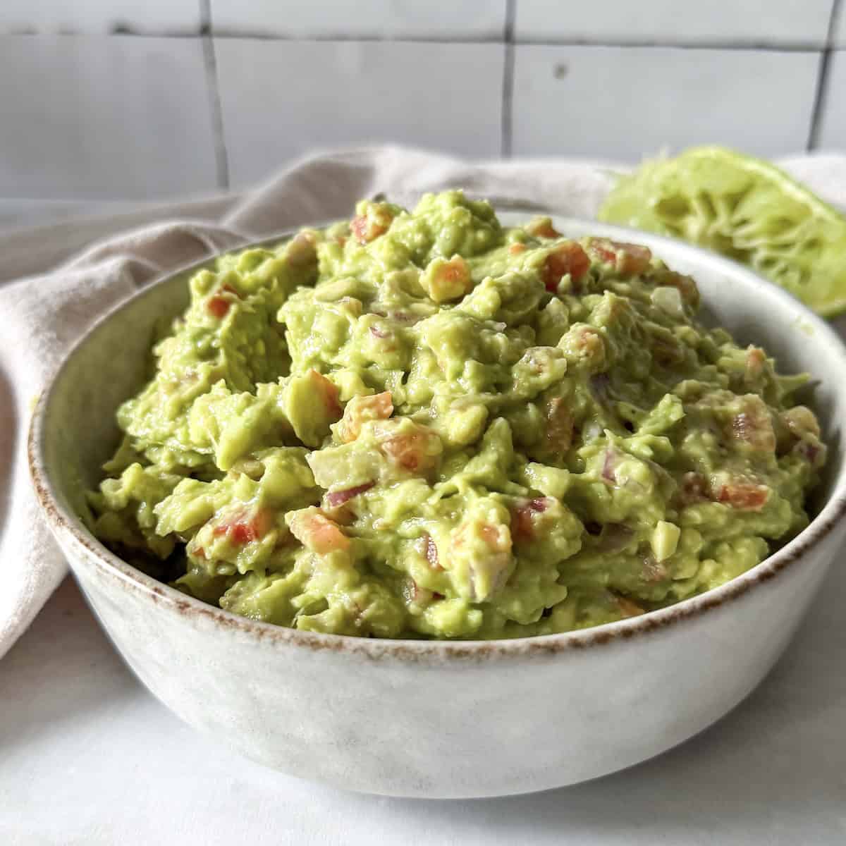 side view of homemade guacamole without cilantro in a bowl.