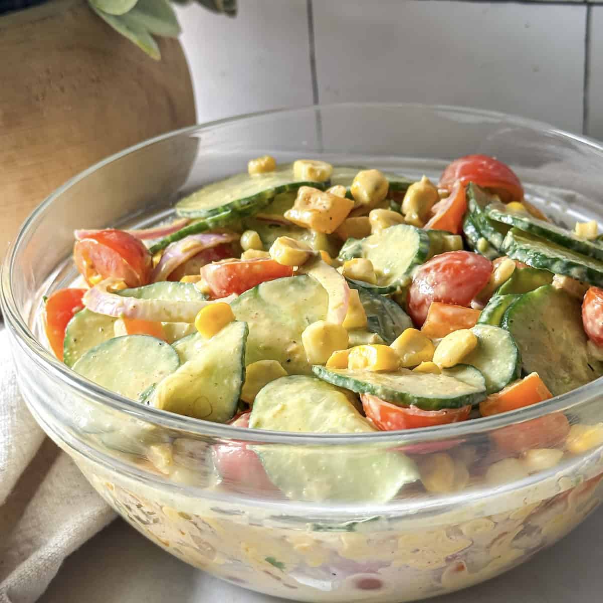 Corn cucumber salad in a glass bowl.