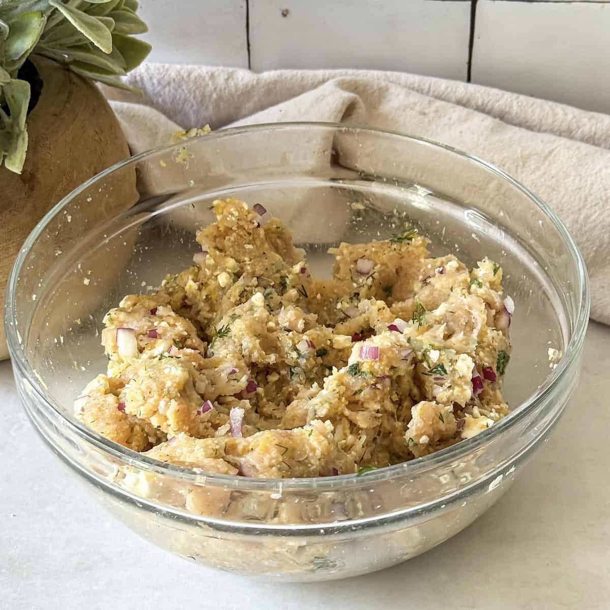 greek chicken meatball ingredients combined in a glass bowl.