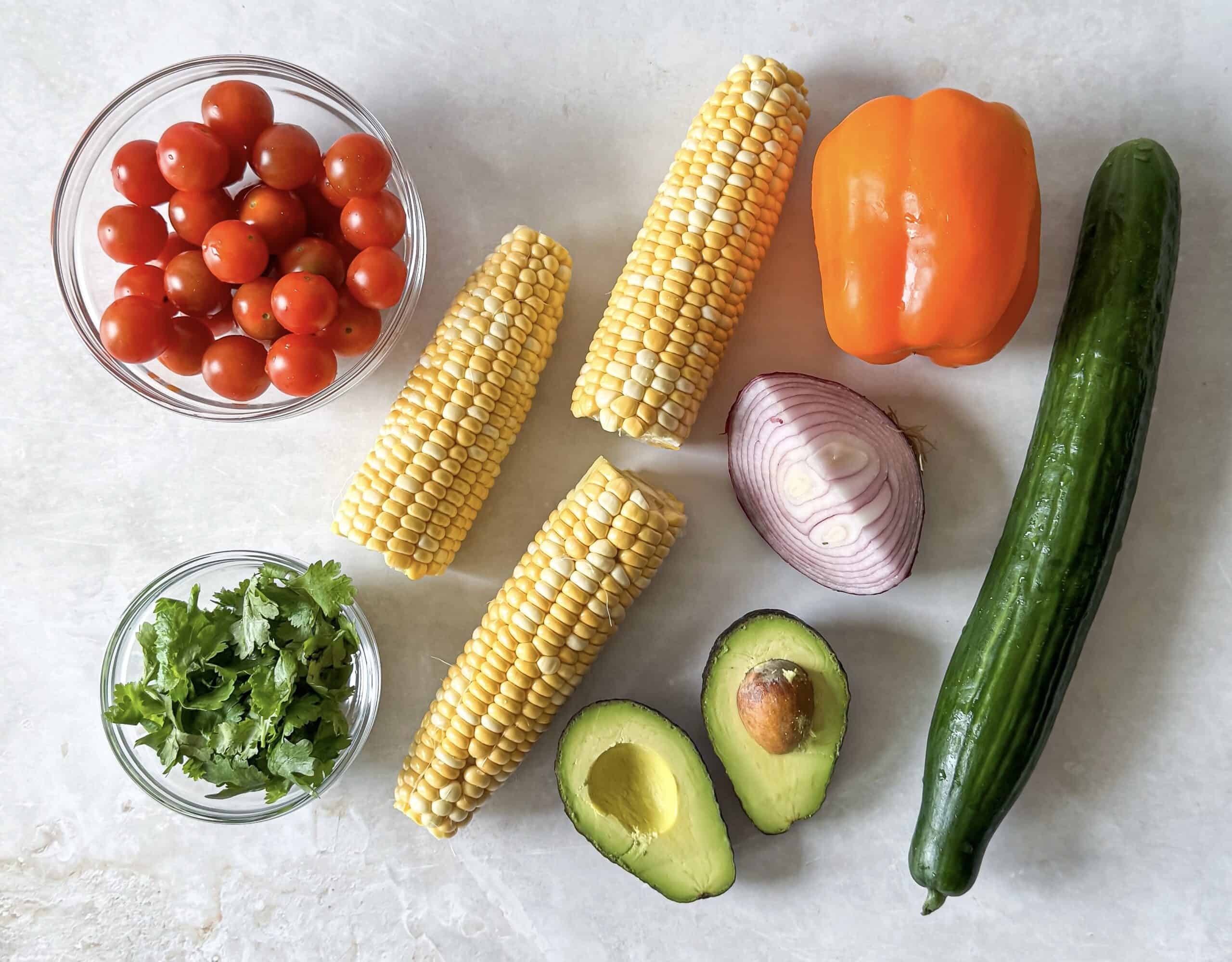 ingredients for corn cucumber salad on a table.