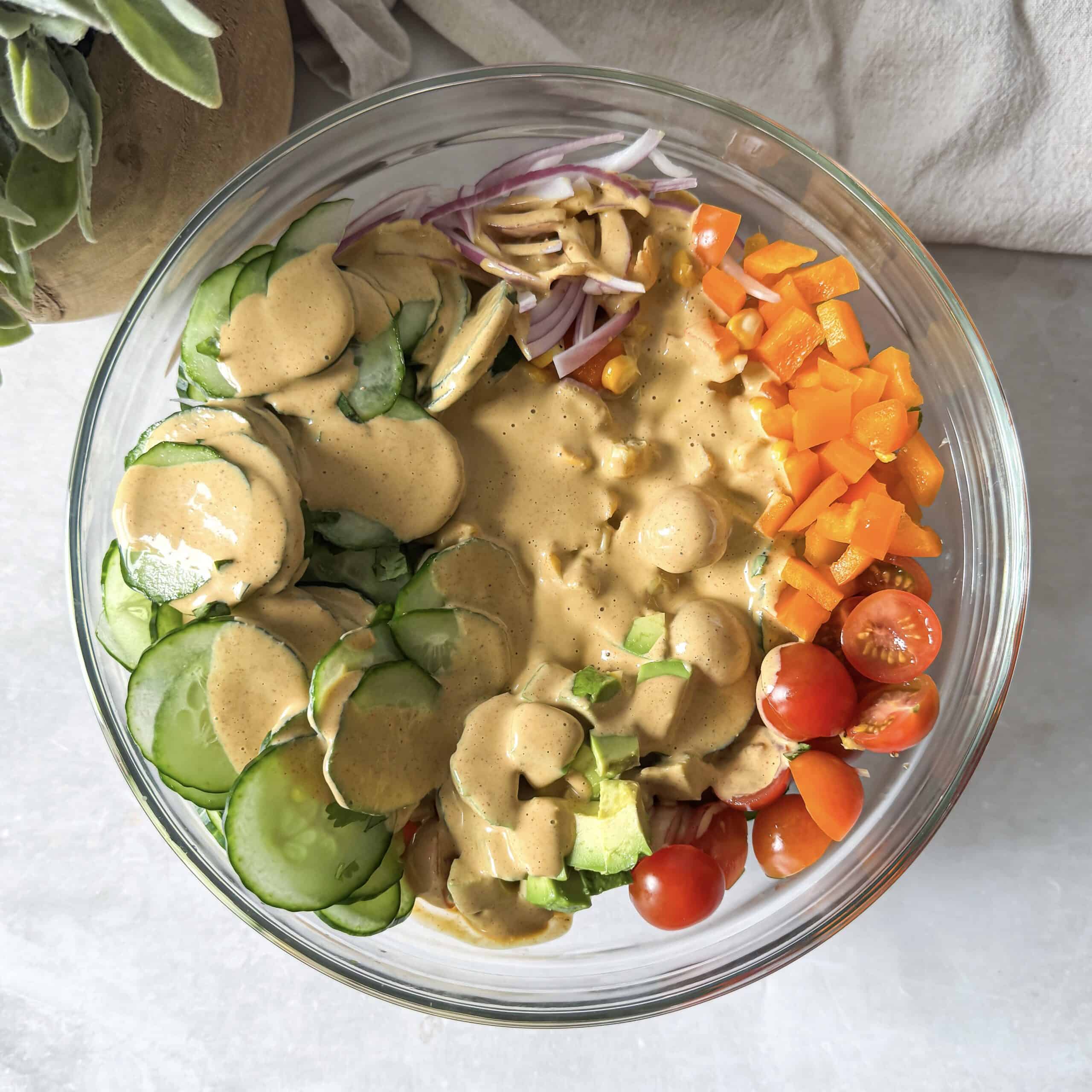 overhead view of corn cucumber salad with dressing added on top.