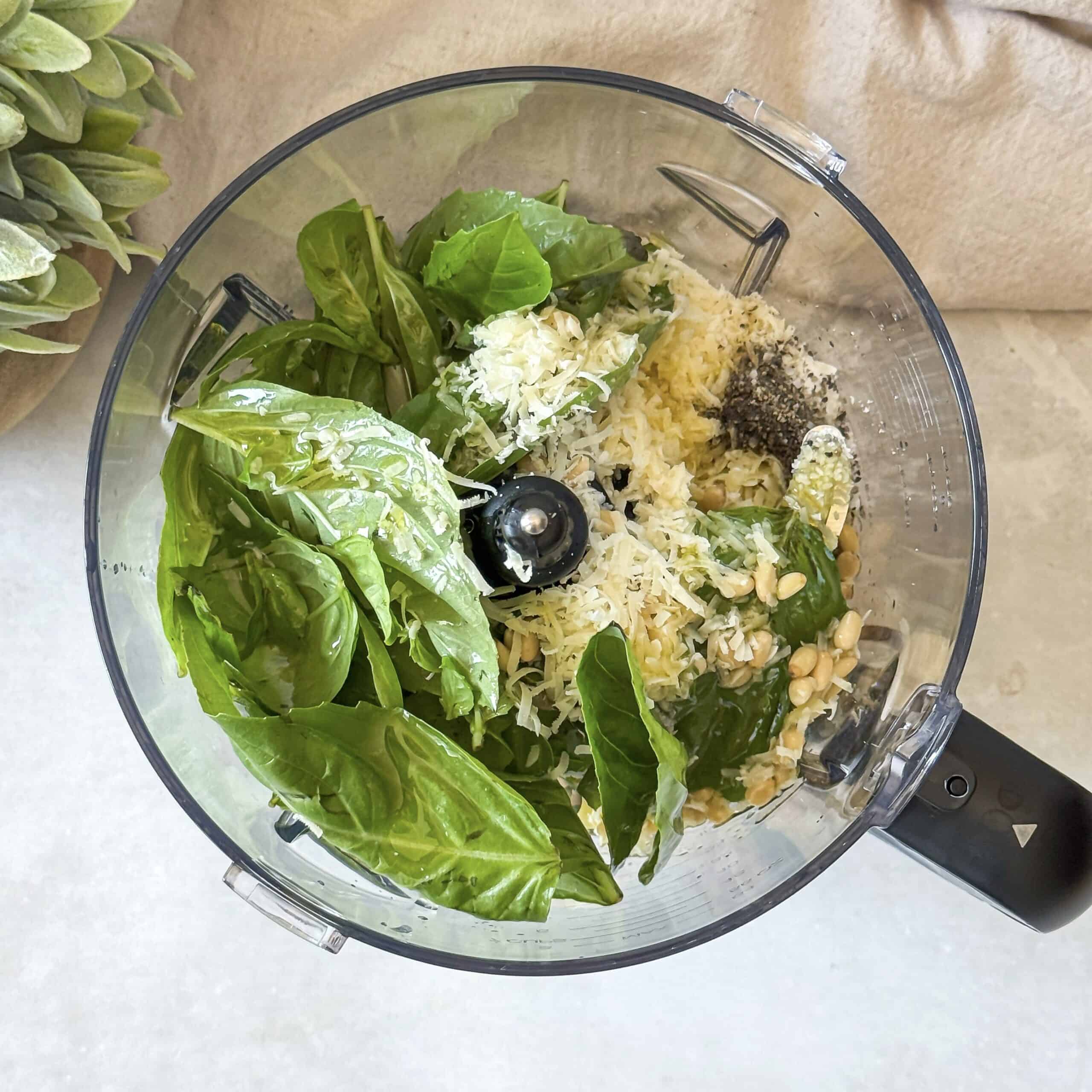 overhead view of pesto ingredients in a food processor