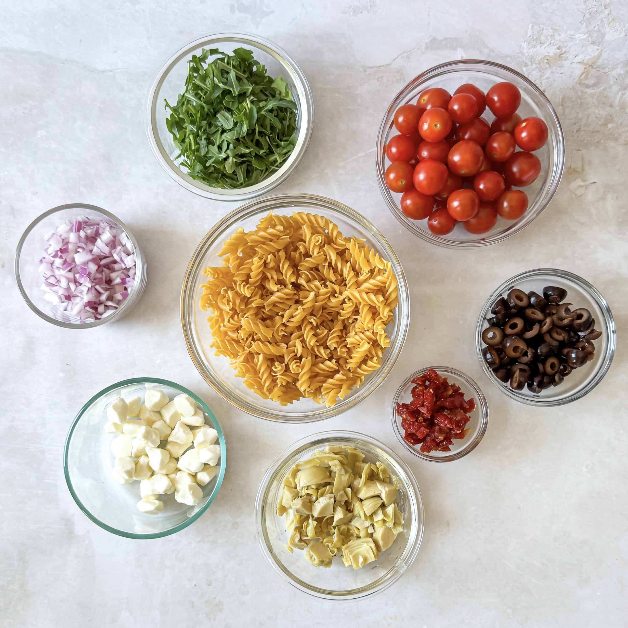 pesto pasta salad ingredients on a table.