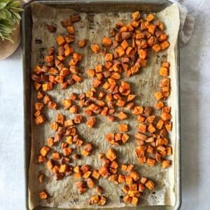 roasted diced sweet potatoes cooked on a baking sheet.
