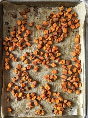 roasted diced sweet potatoes cooked on a baking sheet.