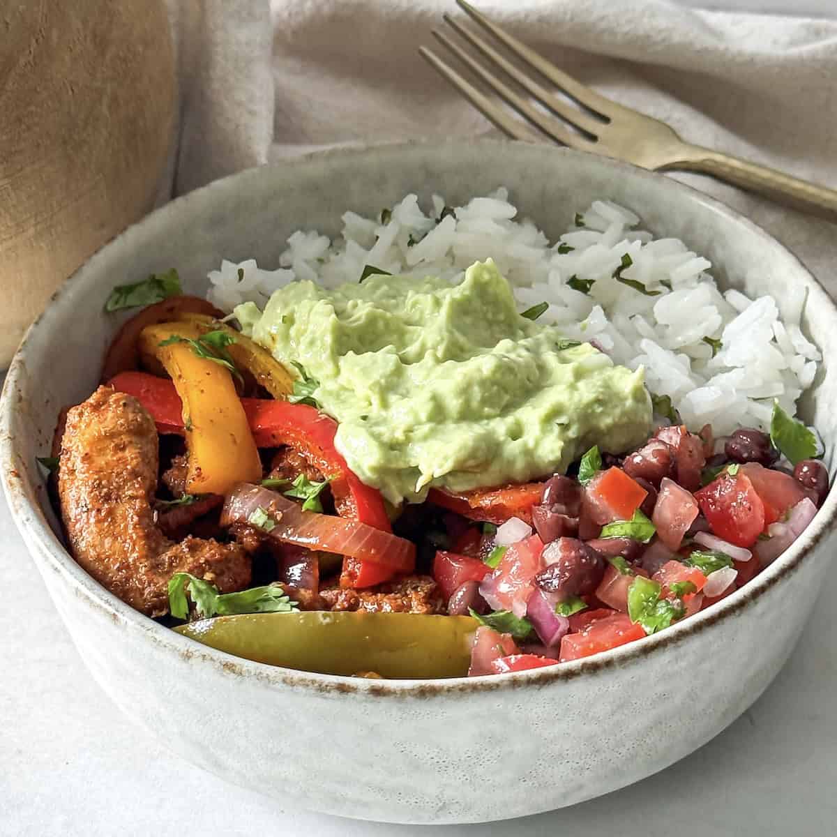 close up side view of chicken fajita bowls.