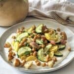 side view of roasted zucchini salad on a plate with a fork.