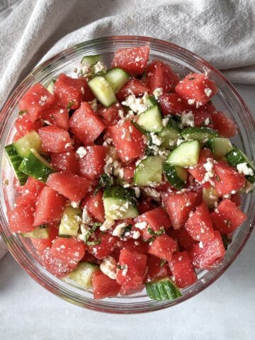 watermelon cucumber salad in a glass bowl further away.