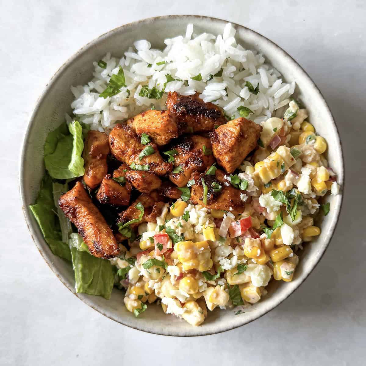 overhead view of street corn chicken rice bowl undressed.