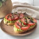 tomato avocado toast on a brown plate.