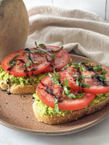 tomato avocado toast on a brown plate.