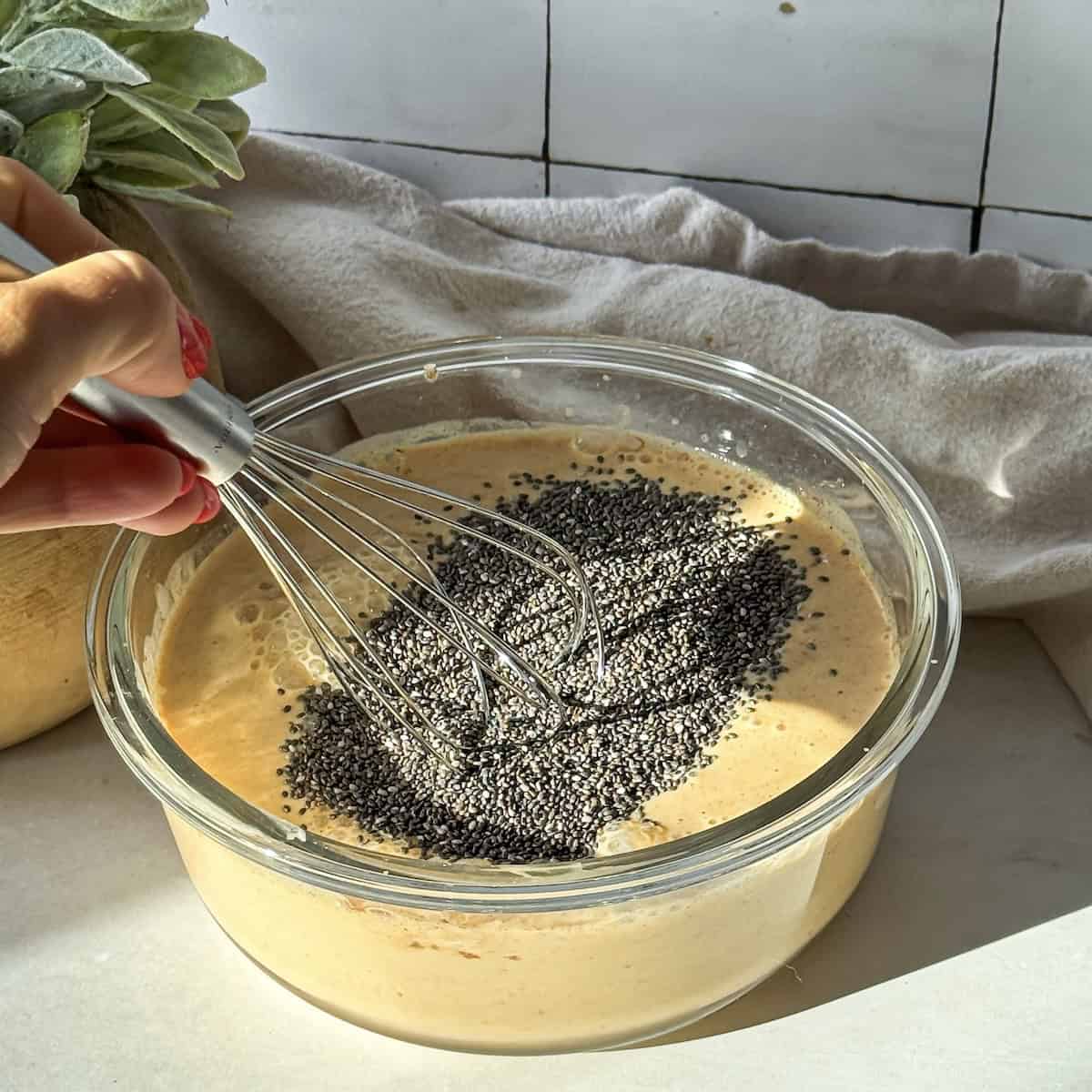 human hand whisking together pumpkin chia pudding.
