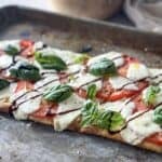 margherita flatbread pizza on a baking sheet.