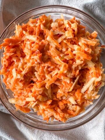 apple carrot salad with greek yogurt dressing in a bowl overhead view.