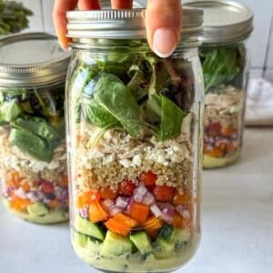 human hand holding a mediterranean salad jar 2