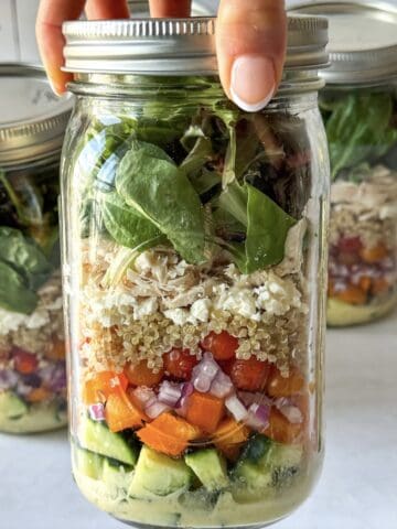 human hand holding a mediterranean salad jar 2