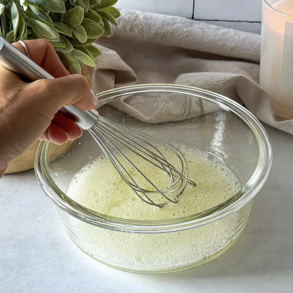 human hand whisking egg whites.
