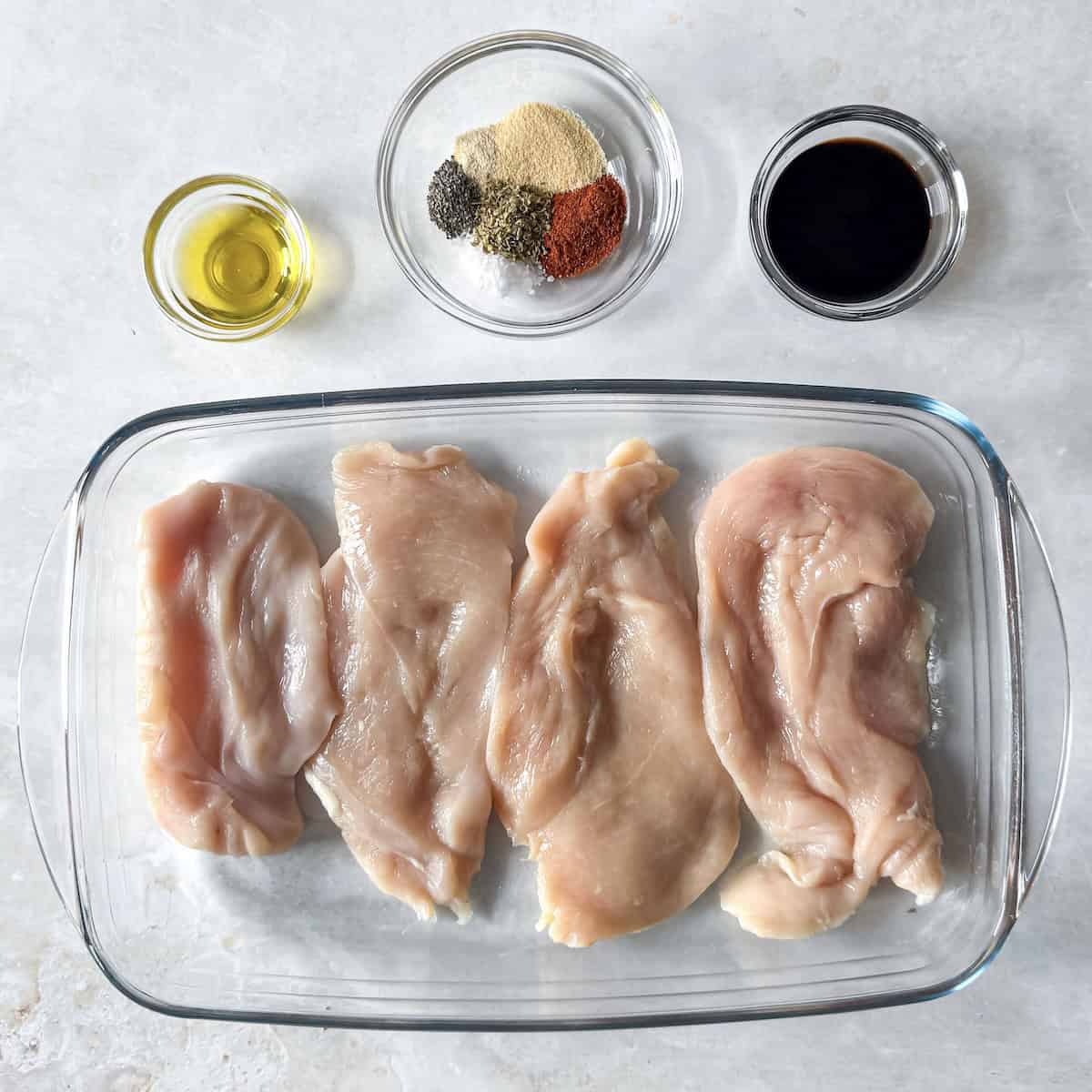 ingredients for baked thinly sliced chicken breast on a table.