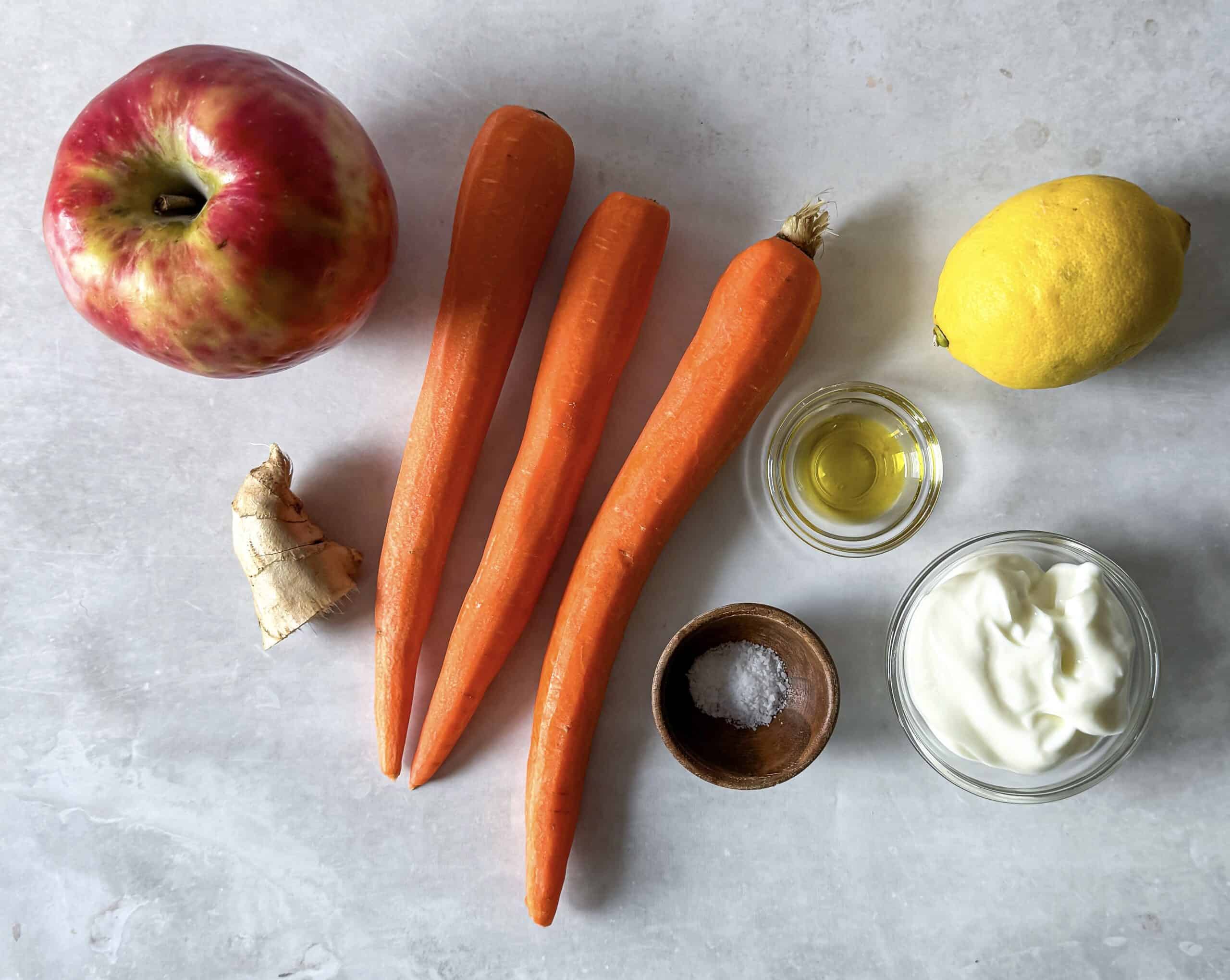 ingredients for carrot apple salad on a table.