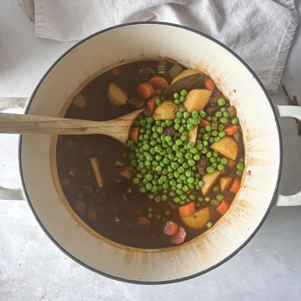 overhead view of beef stew with peas.