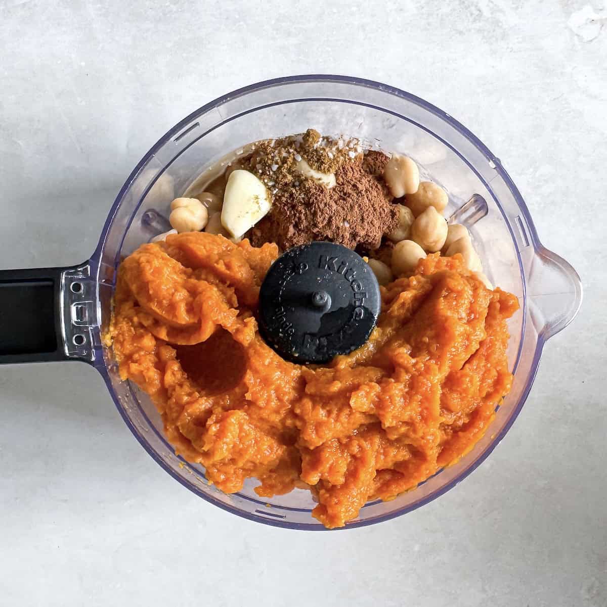 pumpkin hummus ingredients in a food processor.
