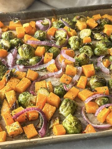 side view of fall roasted vegetables on a sheet pan.