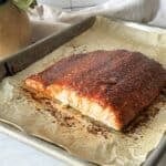 side view of smoked paprika salmon on a baking sheet.