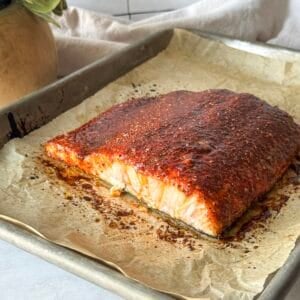 side view of smoked paprika salmon on a baking sheet.