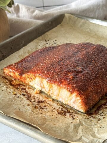 side view of smoked paprika salmon on a baking sheet.