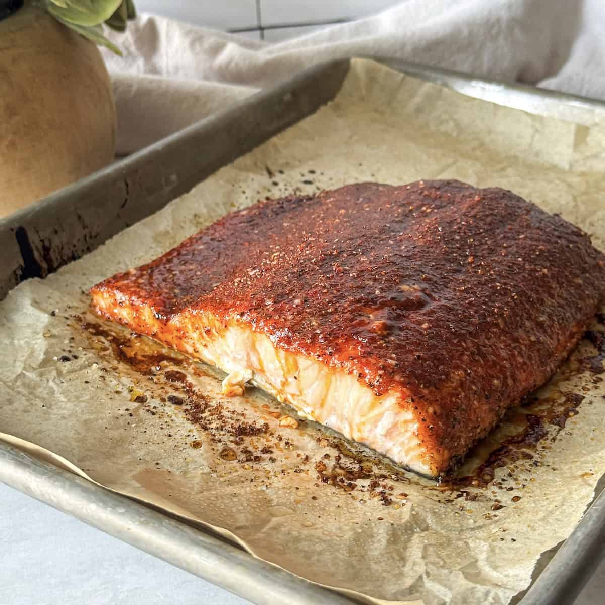side view of smoked paprika salmon on a baking sheet.