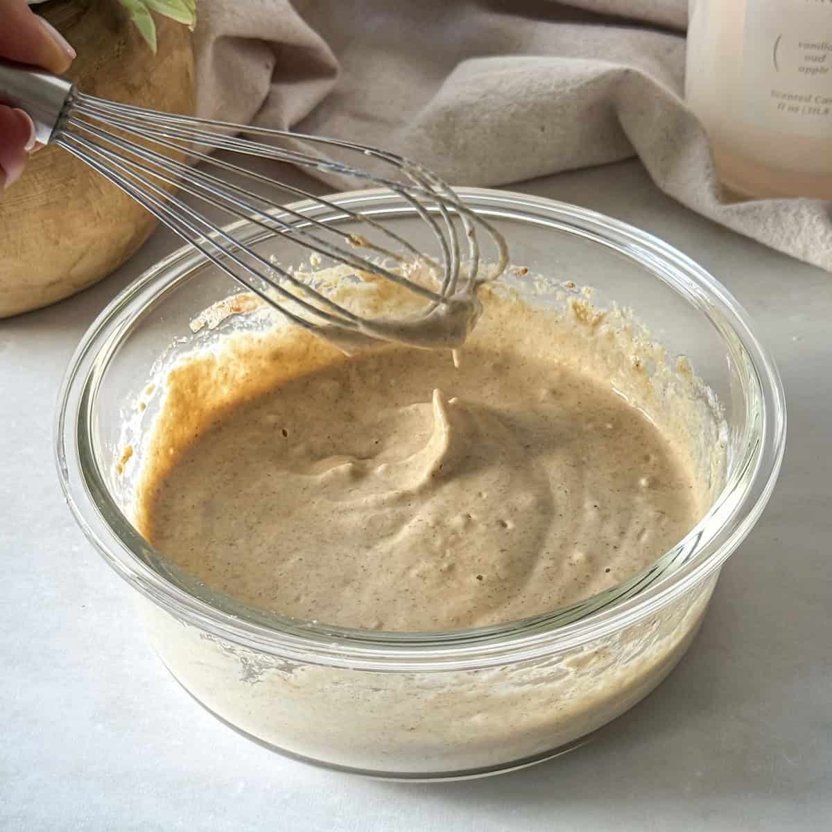 whisk with a protein pancake bowl in a glass container.