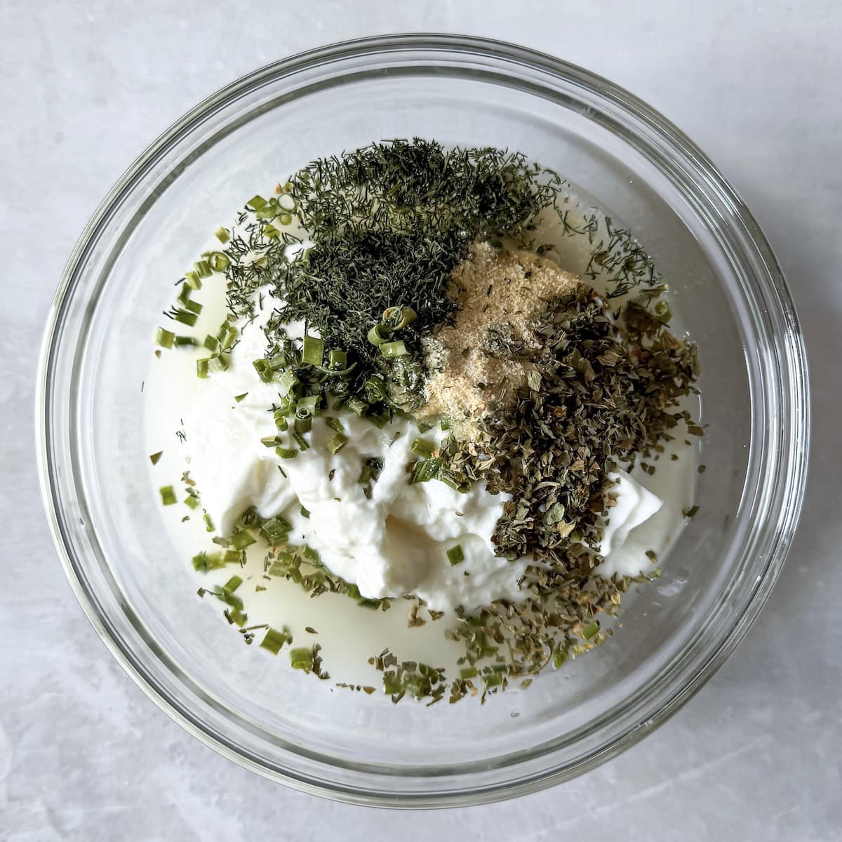 overhead view of homemade ranch dressing ingredients in a bowl.