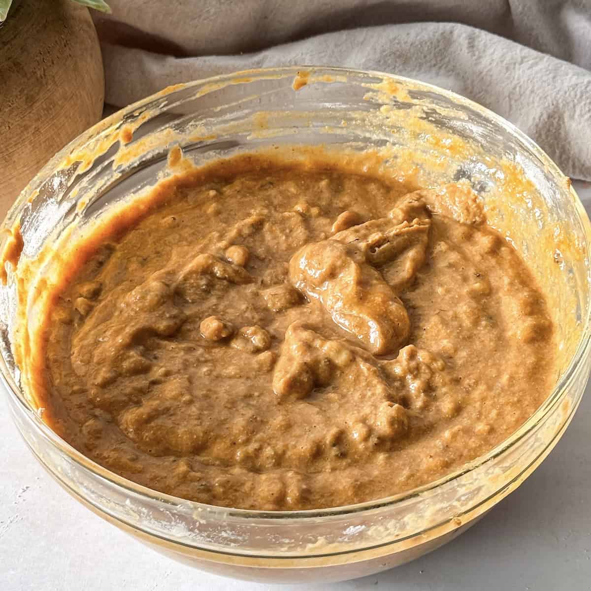 healthy pumpkin banana bread batter in a glass bowl.