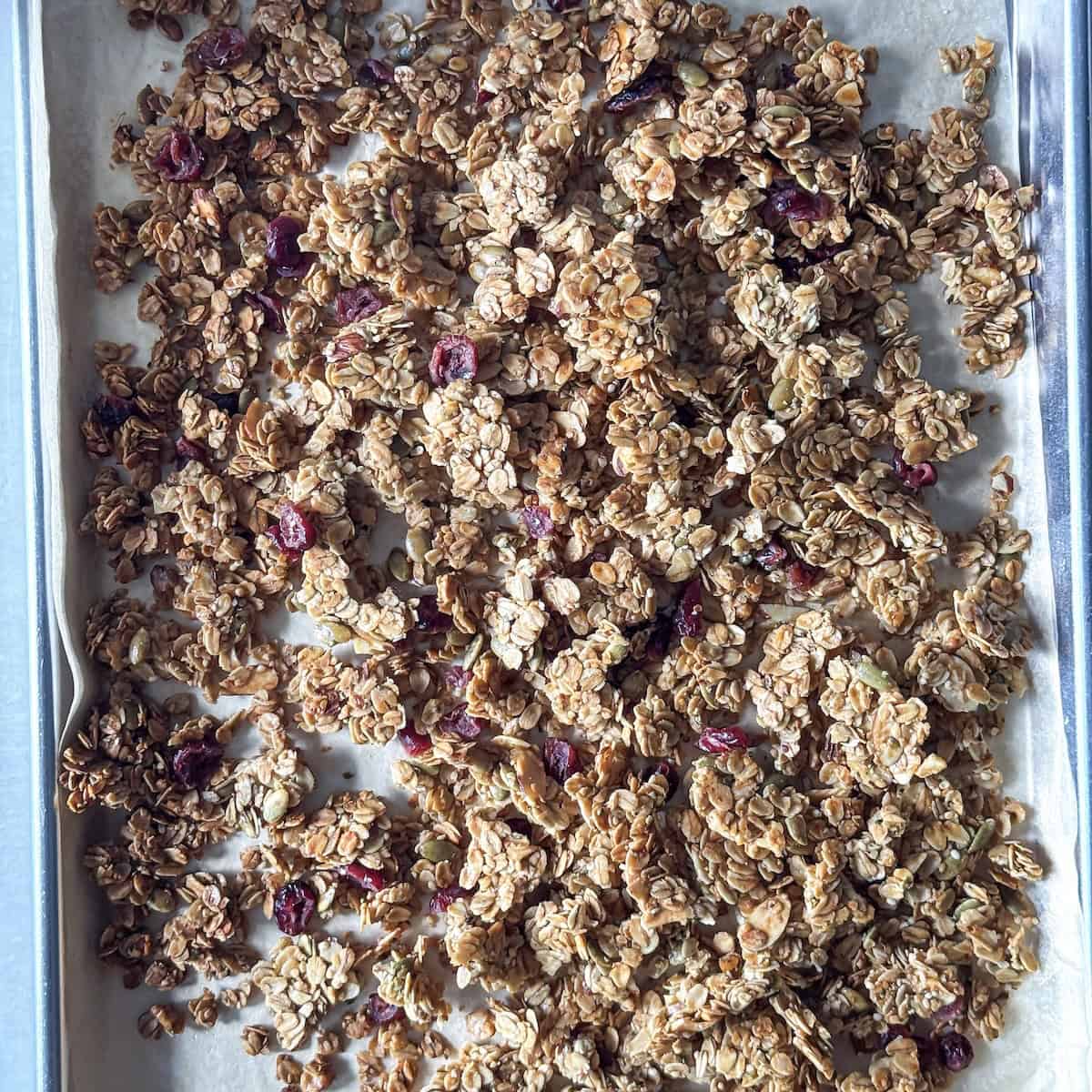 overhead view of healthy granola recipe on a sheet pan.