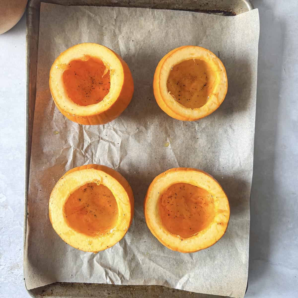 overhead view of pumpkins on a baking sheet.
