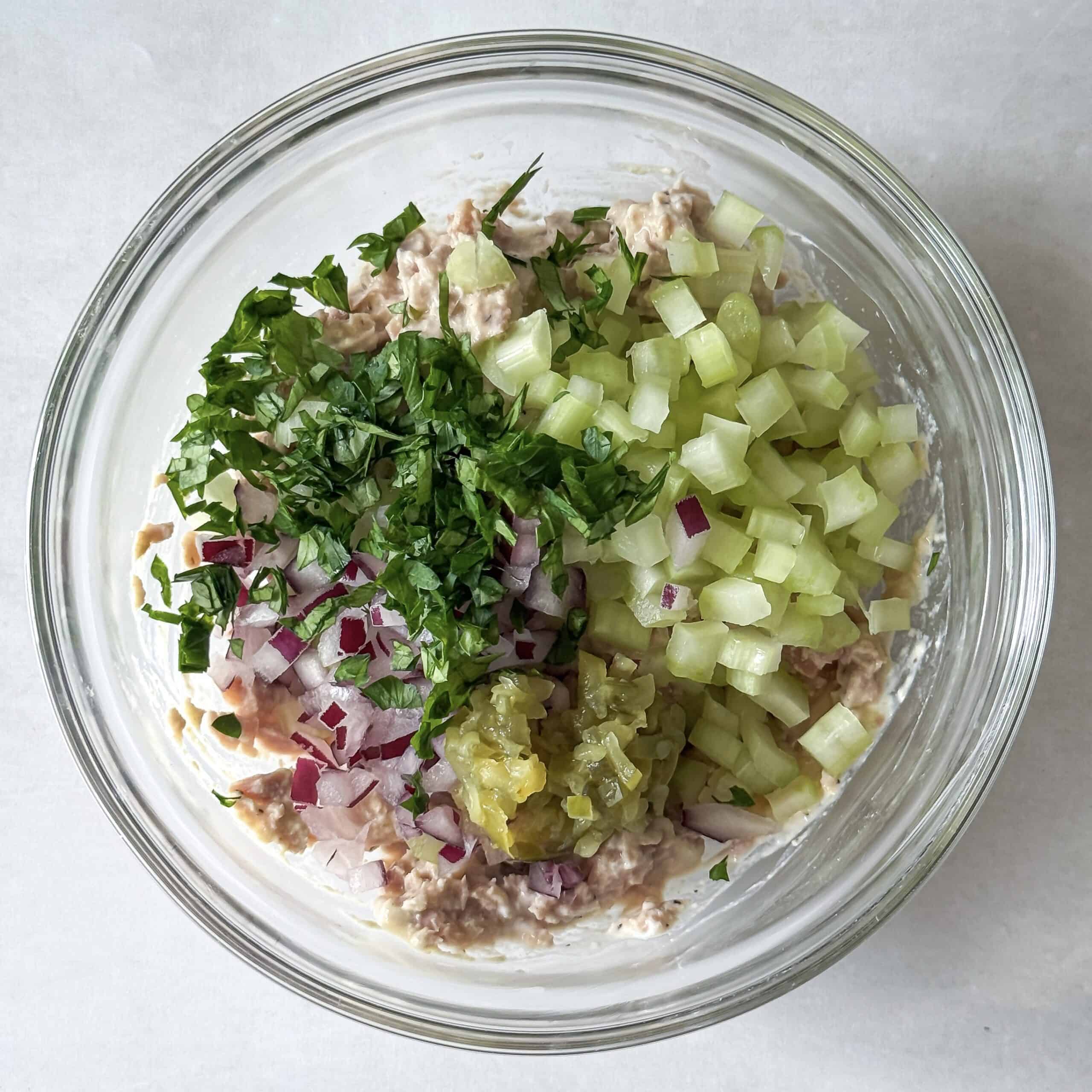 overhead view of tuna salad with veggies, herbs, and pickle relish added.
