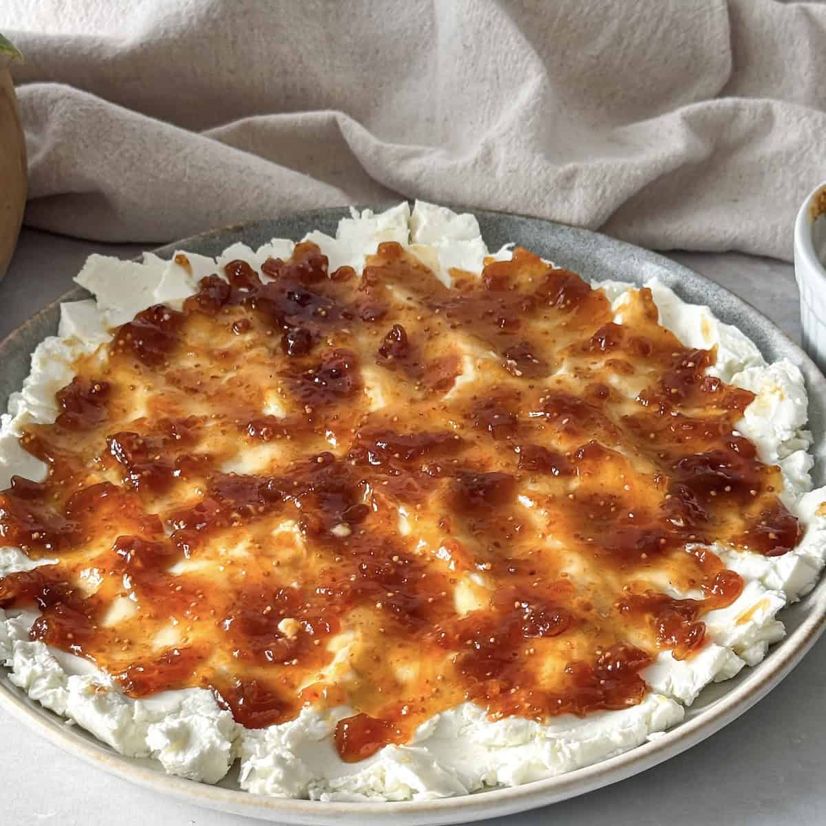 fig jam on top of goat cheese on a plate.