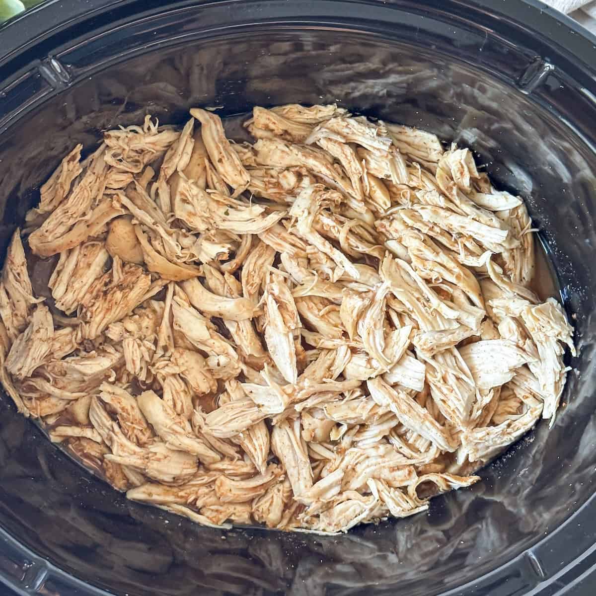slow cooker shredded chicken in a crockpot overhead view.