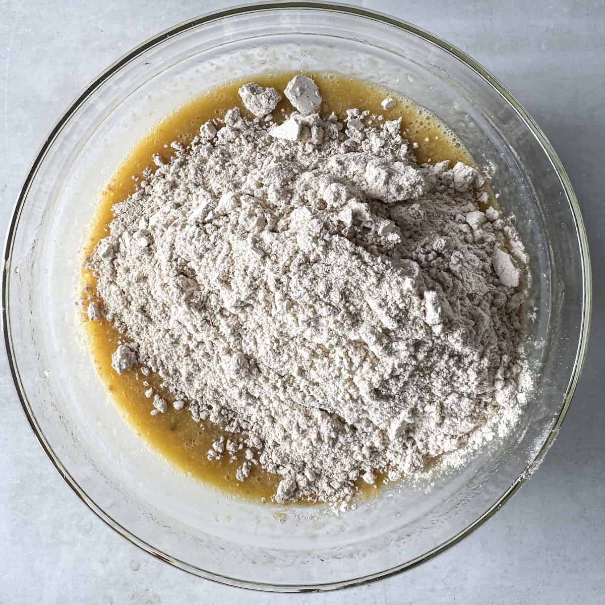 dry ingredients added to wet ingredients for healthy banana bread.