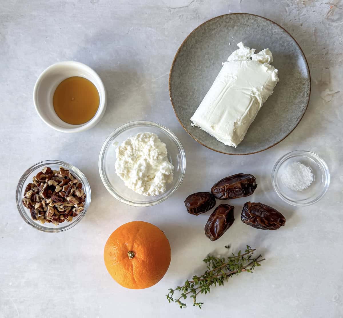 whipped goat cheese dip with pecan date topping ingredients on a table.
