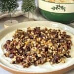 whipped goat cheese dip with pecan date topping side view.