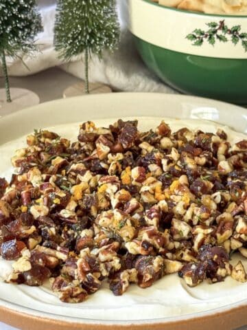 whipped goat cheese dip with pecan date topping side view.